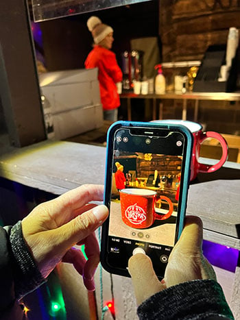 Christina taking a picture of a Christmas mug 