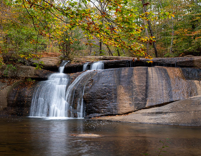 This image features Fall Creek Falls in Mayo River State Park, North Carolina.